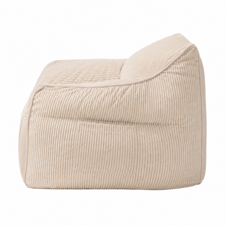 Pouf fauteuil en velours côtelé beige, vue de côté, coutures verticales et renforts.