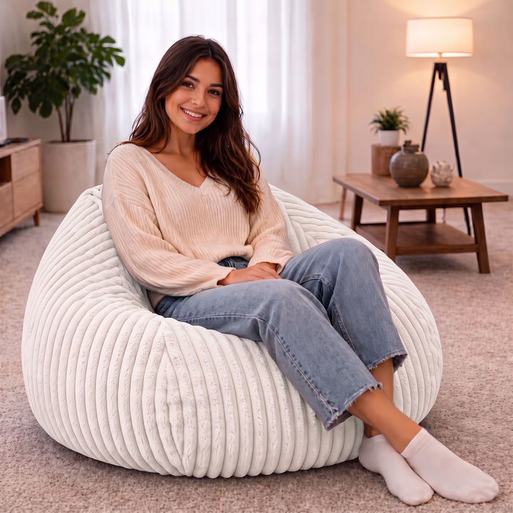 Personne assise confortablement dans un pouf poire en fourrure côtelée