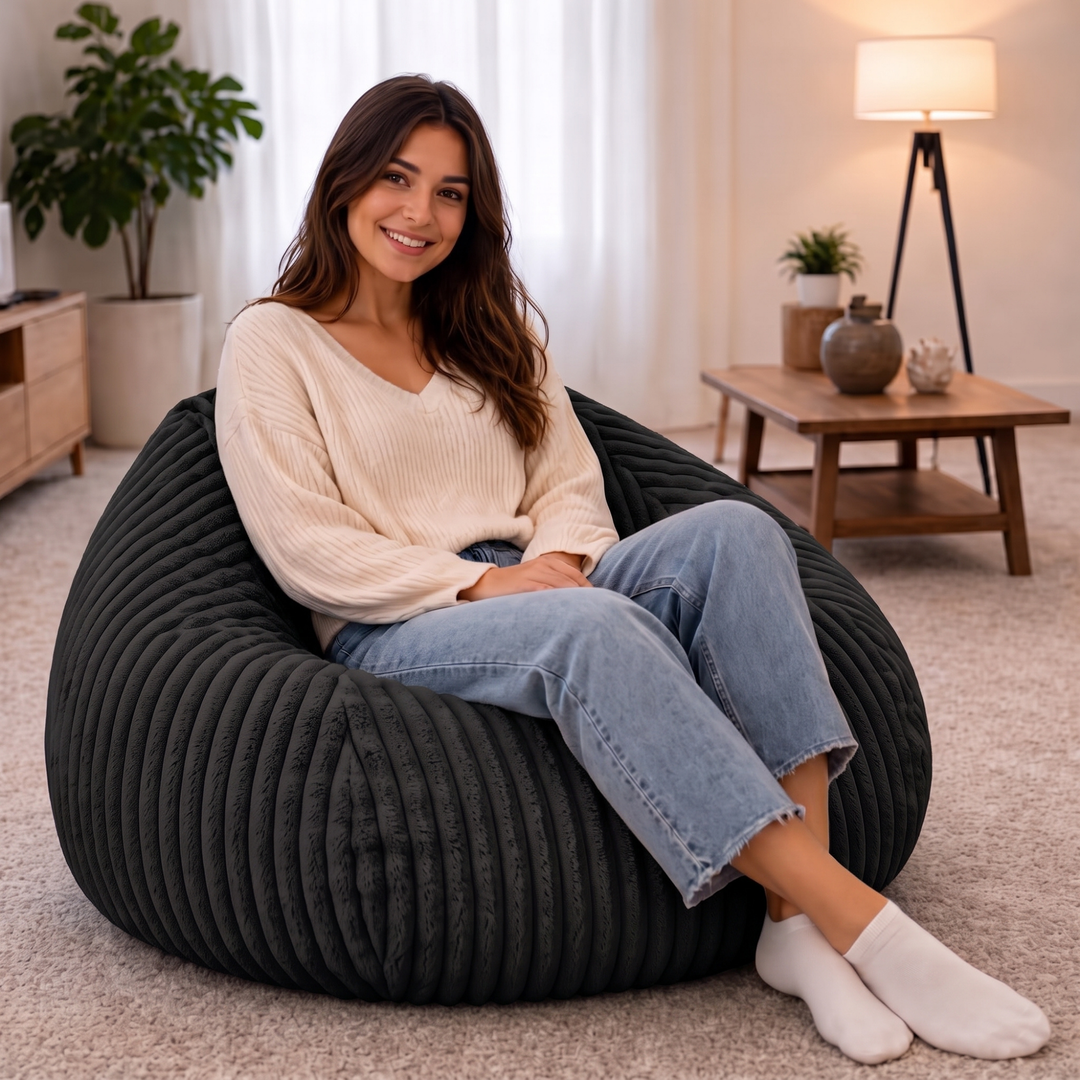 Personne assise confortablement dans un pouf poire en fourrure côtelée