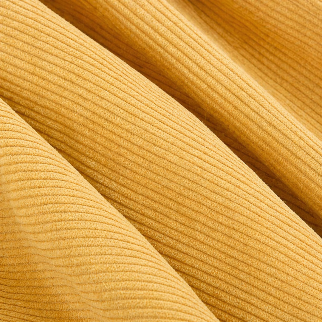 Détail du velours côtelé jaune du pouf, texture à fines nervures