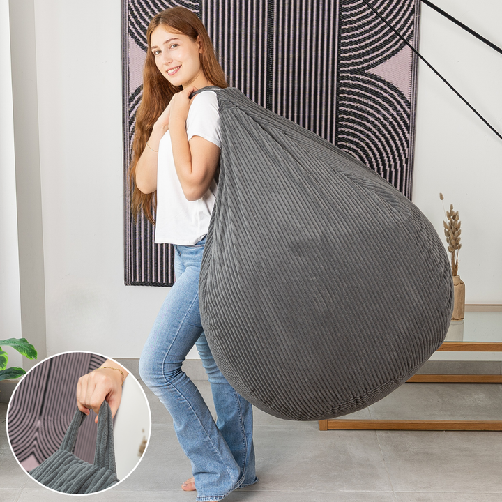 Femme soulevant le pouf poire déhoussable en velours côtelé déhoussable par sa poignée.