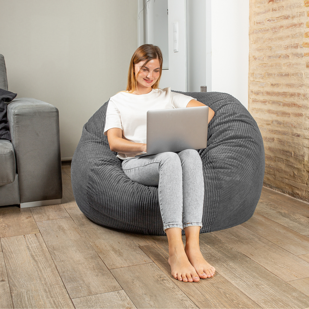 Personne assise sur le pouf-lit convertible 2en1, forme ronde confortable