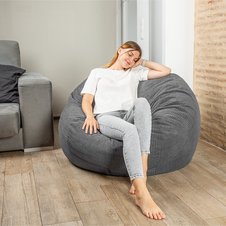 Personne assise sur le pouf-lit convertible 2en1, forme ronde confortable