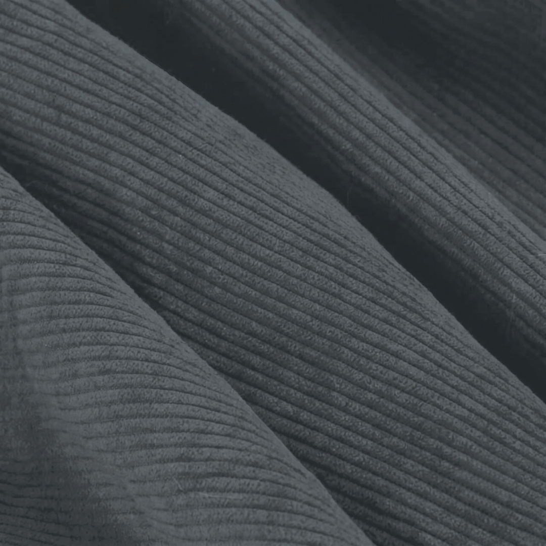 Gros plan du velours côtelé gris foncé avec texture nervurée régulière.