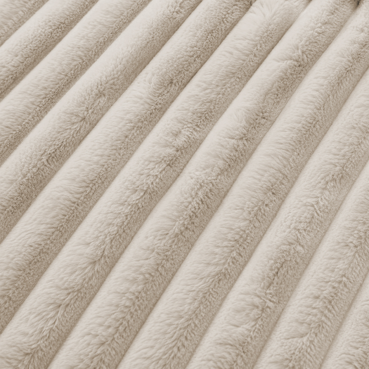 Détail de la fourrure côtelée beige du canapé modulable, texture en relief