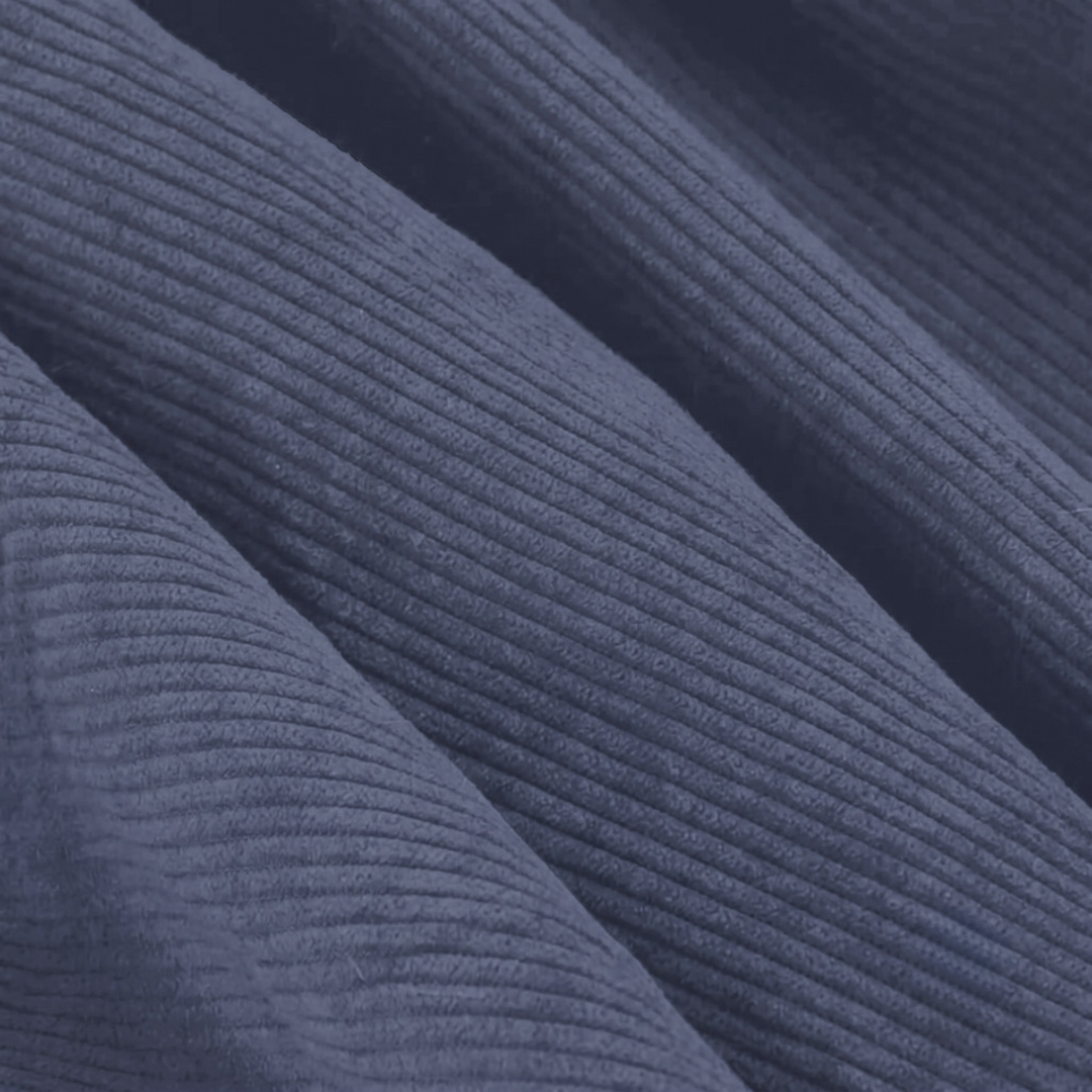 Gros plan du velours côtelé bleu foncé avec texture nervurée régulière.