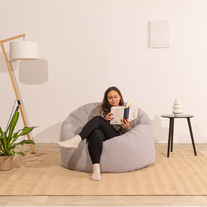 Personne assise confortable sur un pouf en velours côtelé épais