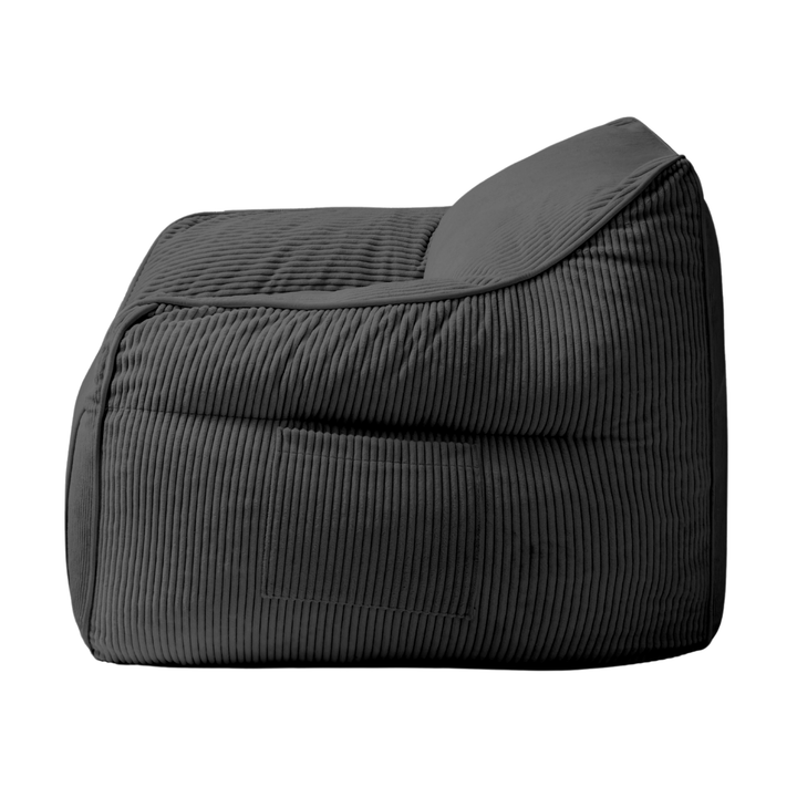 Pouf fauteuil en velours côtelé gris foncé, vue de côté, coutures verticales et renforts.