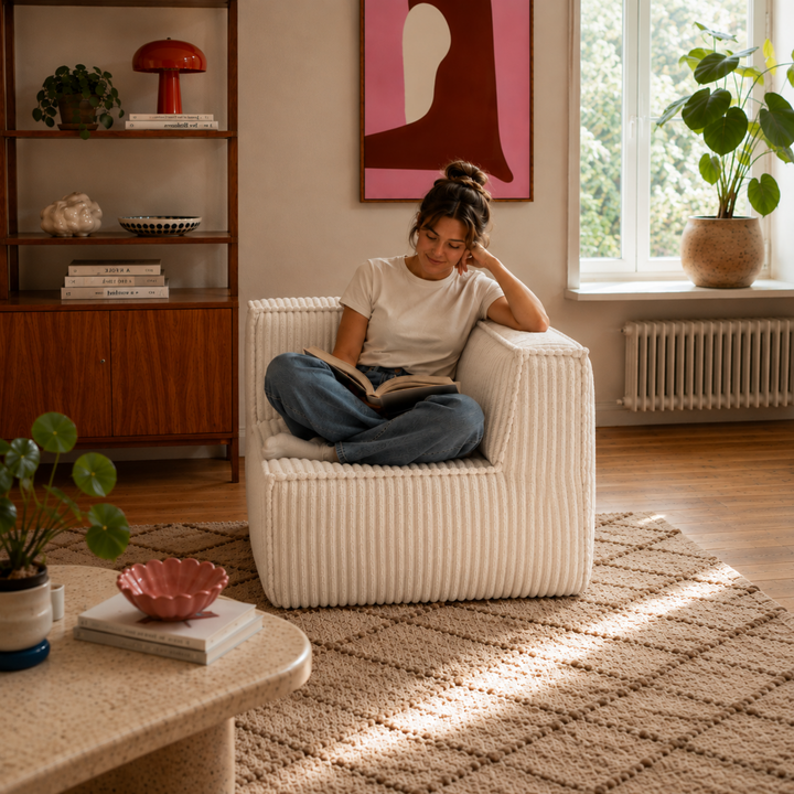 Personne assise sur le module d’angle de canapé en velours côtelé blanc cassé, assise compacte pour coin