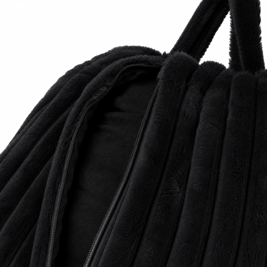 Ouverture zippée de la housse noire du pouf poire en fourrure côtelée