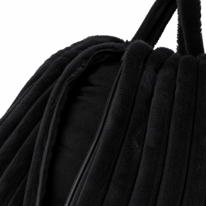Ouverture zippée de la housse noire du pouf poire en fourrure côtelée