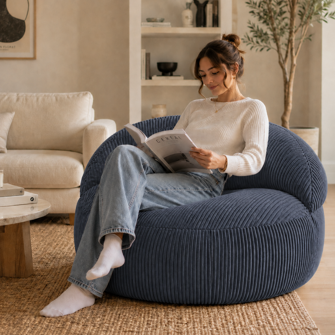Personne assise sur un pouf XXL en velours côtelé, dans un salon